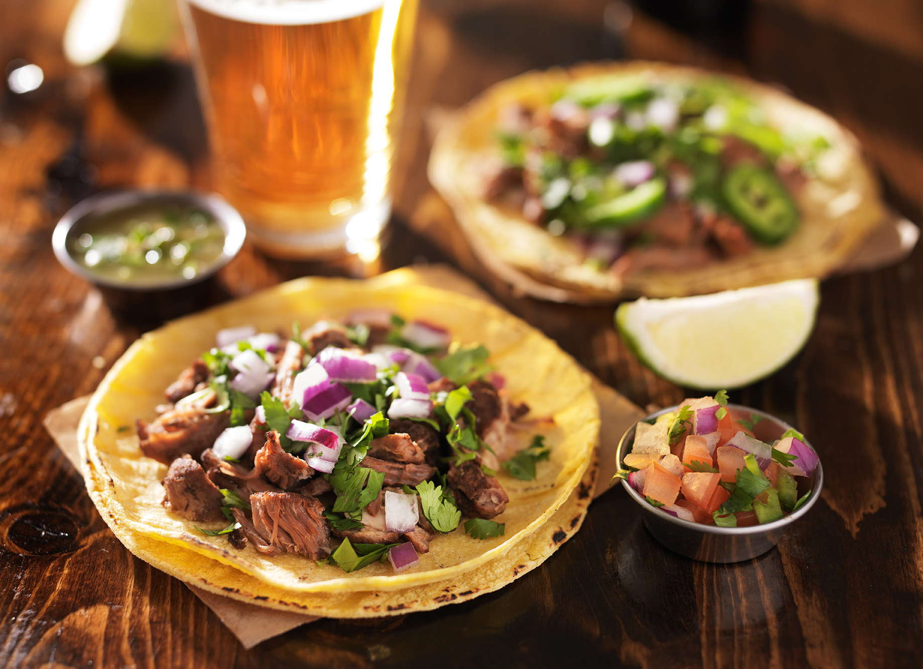 authentic mexican tacos with beer on wooden table
