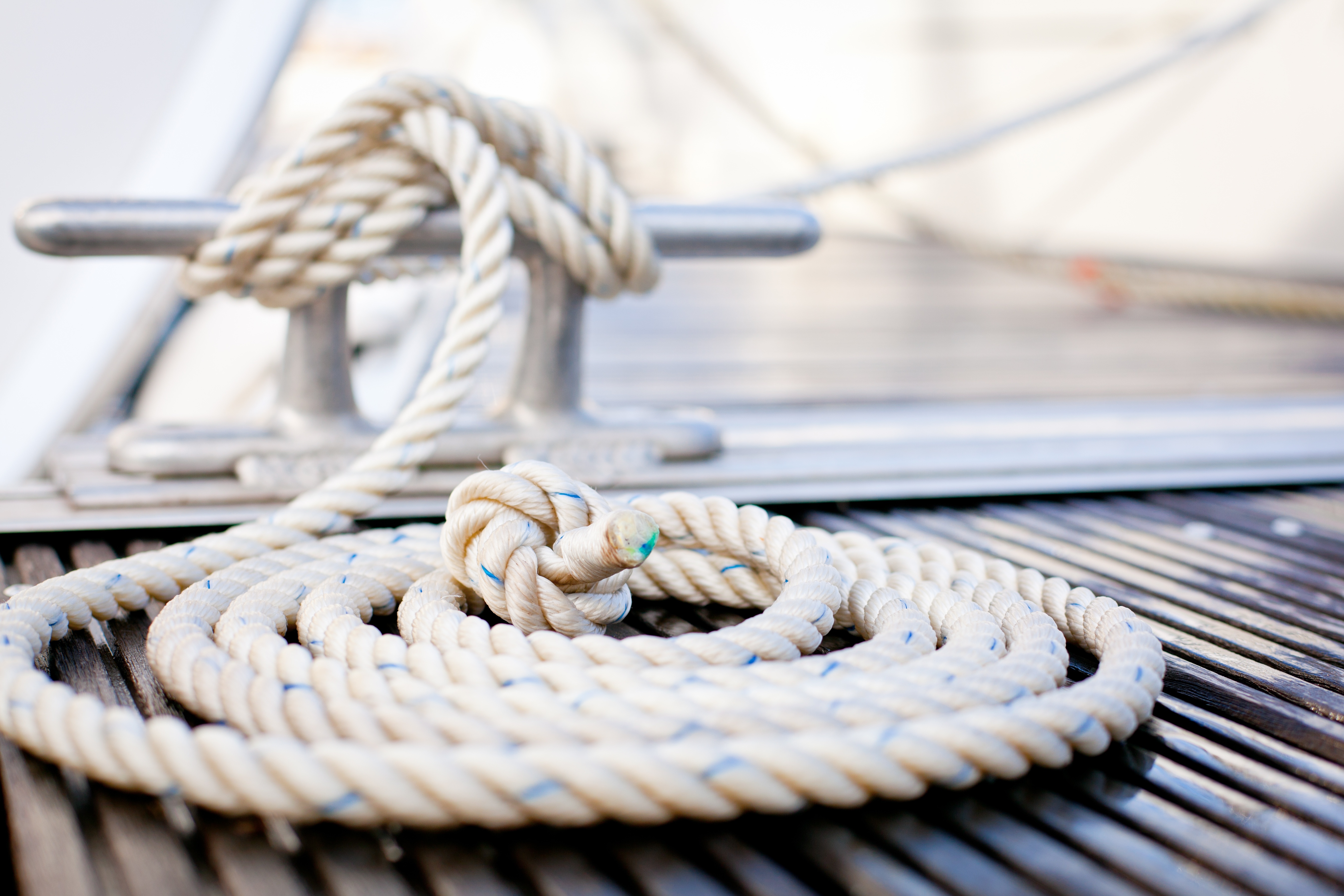 10445594 - close-up of mooring rope with a knotted end tied around a cleat on a wooden pier.